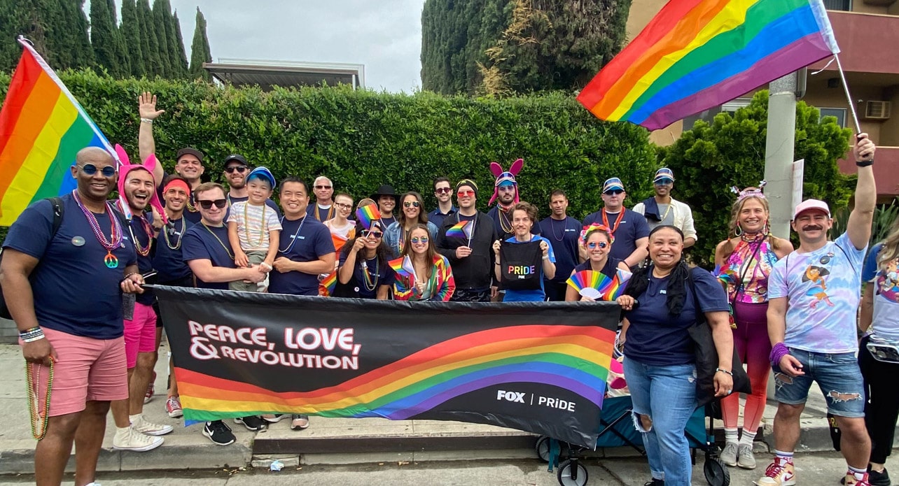 A large group of FOX employees posing together at a PRIDE event