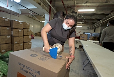 A FOX employee using packing tape to seal a box.